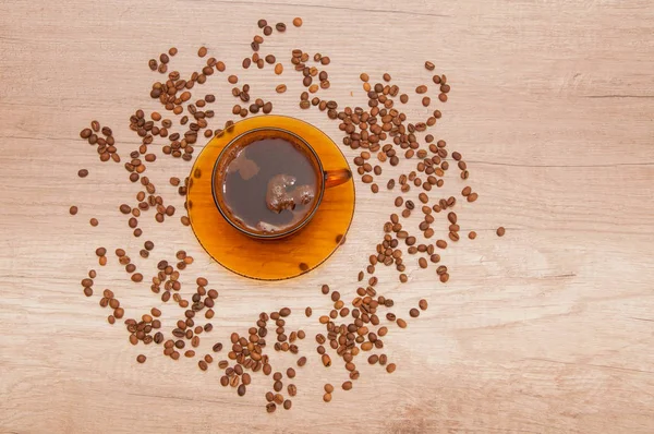 Coffee cup in a coffee beans table chaos