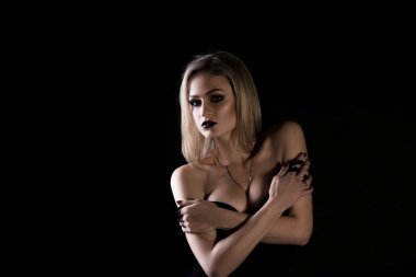 Siyah arka planda siyah elbiseli bir kız.