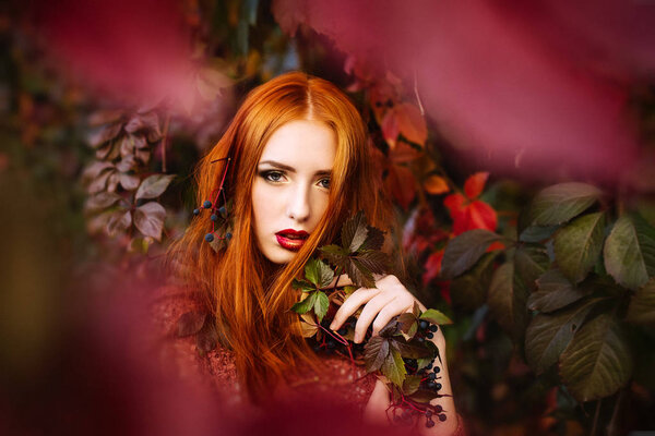 The red-haired girl in the leaves of wild grapes