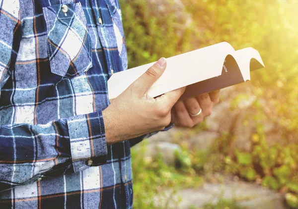 Un hombre leyendo un libro en el parque. Estudiante estudiando memorizar notas al aire libre . —  Fotos de Stock