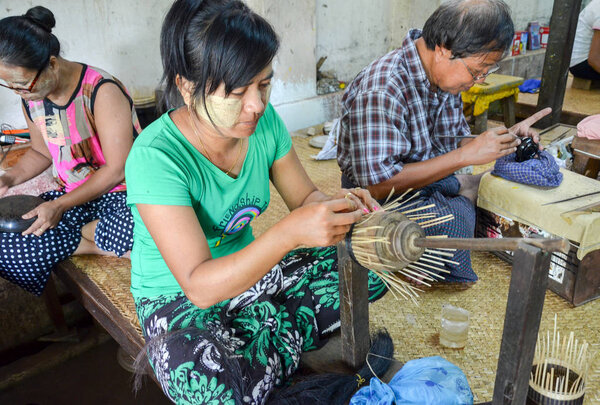 BAGAN, MYANMAR- SEPTEMBER 12, 2016: Burmese people making lacquerware dishes at a local factory in Old Bagan