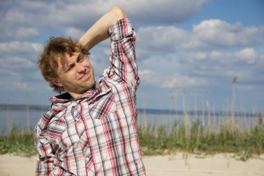 Adamın kafasını tek elle tutarak ekose gömlekli. 