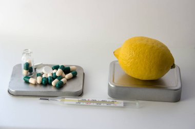 Tabletler ve kapsüller içinde... bir limon ve termometre