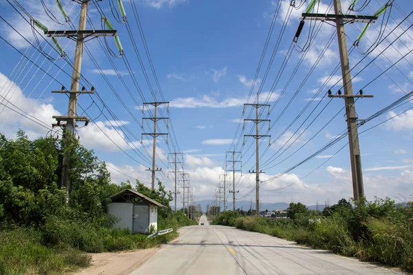 electric power line on road with sky background. Electricity poles and power cable with blue sky