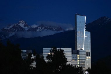 Almatı, Kazakistan - 05 Haziran 2017: Al-Farabi sokak görünümü ile Esantai kulede Almatı, Kazakistan, Kazakistan (Bahar, yaz). Windows binanın gün batımının yansıma.