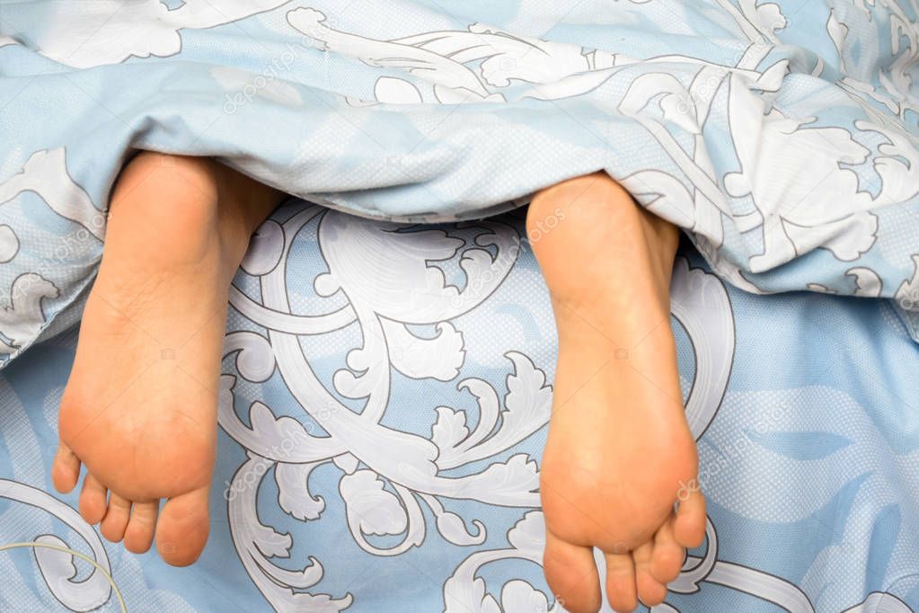 Legs of a sleeping girl on the bed.