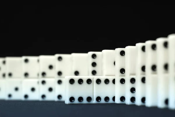 Donino chips on black. Maximum score chip as a accent in the domino line. Business concept idea. Close up view.
