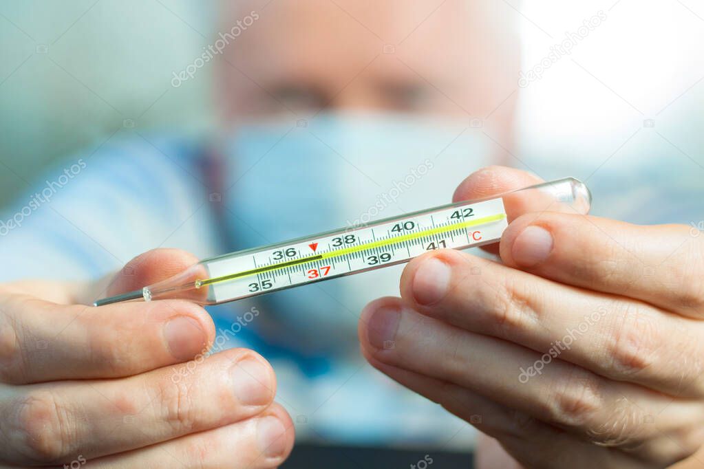 Doctor shows the thermometer that mark the fever.