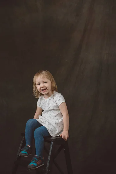 Little girl in studio on dark background — Stock Photo, Image