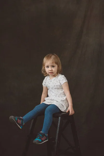 Little girl in studio on dark background — Stock Photo, Image