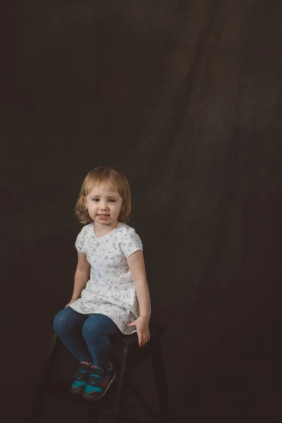 Little girl in studio on dark background — Stock Photo, Image