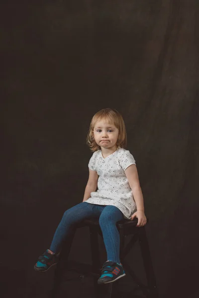 Little girl in studio on dark background — Stock Photo, Image