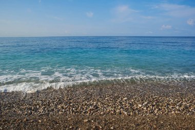 Sakin mavi deniz ve çakıl plajı ve mavi gökyüzü