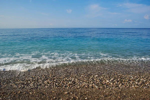 Sakin mavi deniz ve çakıl plajı ve mavi gökyüzü