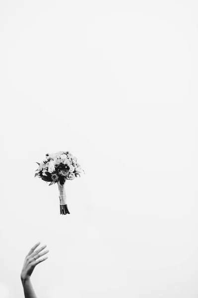 Main et le bouquet de la mariée dans l'air — Photo