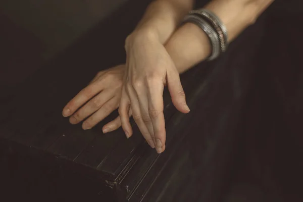 Braccia incrociate ragazza su uno sfondo di legno scuro in bracciali d'argento da vicino — Foto Stock