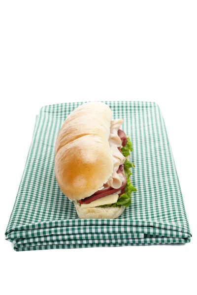 Un sandwich au bacon sur le tissu vert — Photo