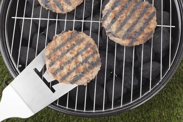 Hamburgers grilling on charcoal grill — Stock Photo, Image