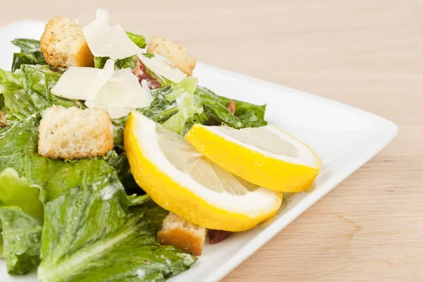 Prato de salada de ceasar com fatias de limões — Fotografia de Stock