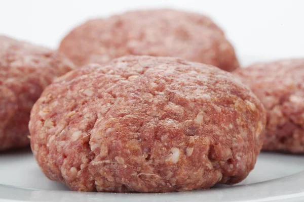 Hamburguesas de carne cruda contra blanco — Foto de Stock