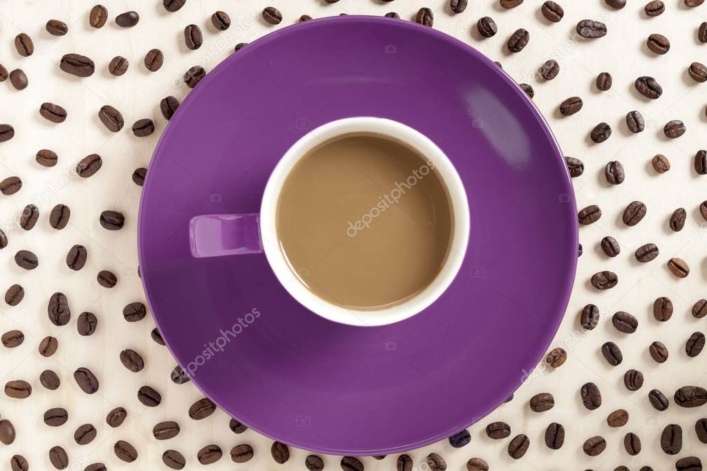hot chocolate in a cup in violet plate with coffee beans