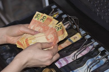 Yazar kasa Brezilya para banknot ve madeni paraların ile pazarlamacı ellere