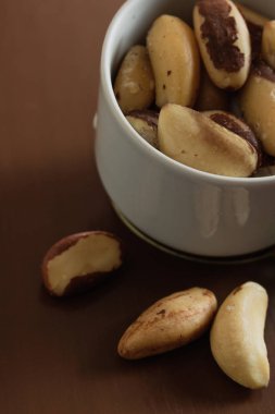 Tahta bir masada kasede Brezilya fındıkları. Mutfak arka planı.