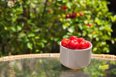Bahçe masasında bir kasede Acerola meyvesi, tipik Brezilya fr.