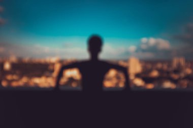 Şehrin siluetinde silueti olan genç bir adam.