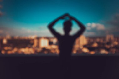 Şehrin siluetinde silueti olan genç bir adam.