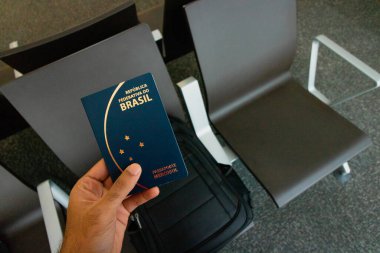 Elinde Brezilya pasaportu, sırt çantası var. Seyahat konsolu.