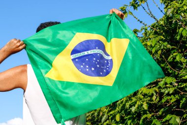 Brezilya bayrağını rüzgarda tutarken. 