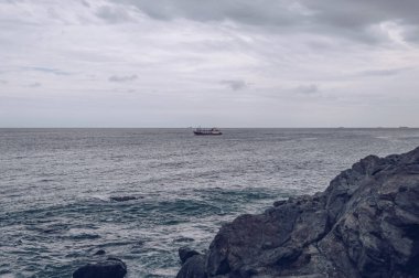 Kasvetli bir günde Busan 'ın kıyısından küçük bir tekne manzarası