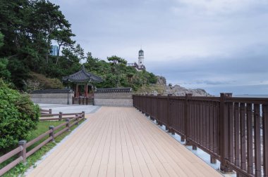 Dongbaek deniz feneri manzarası kasvetli bir günde Naru parkının bir kısmından