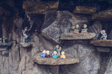 Busan, Güney Kore, 12 Eylül 2019: Haedong Yonggung Tapınağı 'ndaki taş duvarın içinde çeşitli küçük budalar