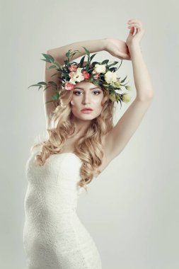 başında beyaz zemin üzerine çiçek çelenk ile kız