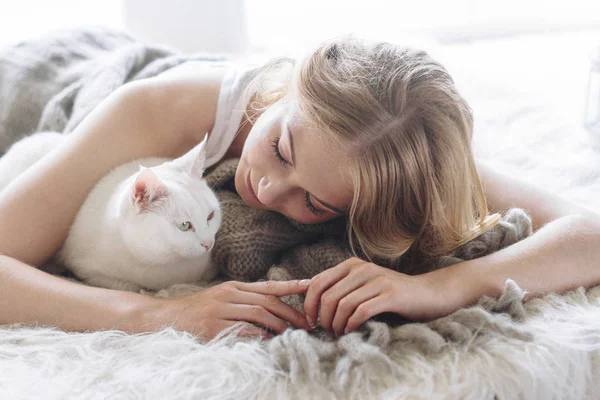 Beautiful sexy blonde lies on the window along with the cat — Stock Photo, Image