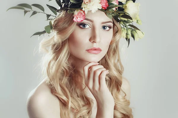 Menina com uma coroa de flores na cabeça sobre fundo branco — Fotografia de Stock