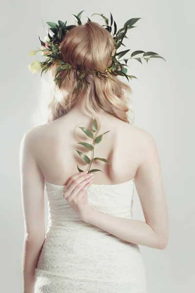 Chica con una corona de flores en la cabeza sobre fondo blanco — Foto de Stock