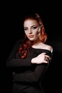siyah bir arka plan üzerinde siyah elbiseli seksi redhead kız. Güzellik