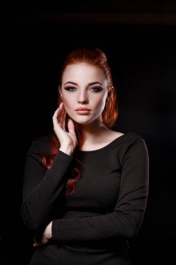 siyah bir arka plan üzerinde siyah elbiseli seksi redhead kız. Güzellik