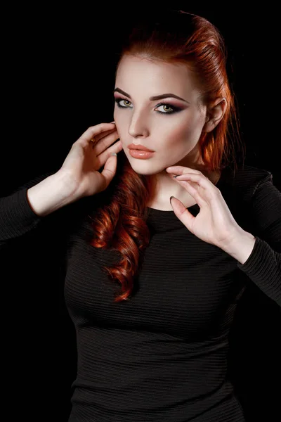 Sexy roodharige meisje in zwarte jurk op een zwarte achtergrond. schoonheid — Stockfoto