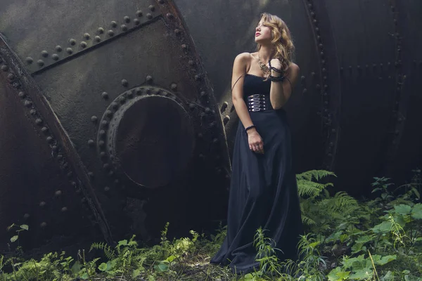 Blond flicka i svart klänning på en gammal övergiven fabrik. Steampunk — Stockfoto