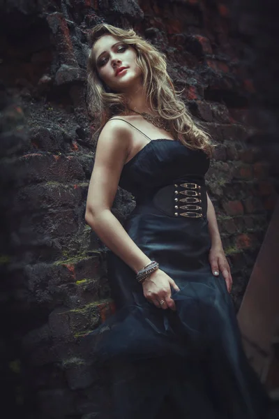 Blond flicka i svart klänning på en gammal övergiven fabrik. Steampunk — Stockfoto