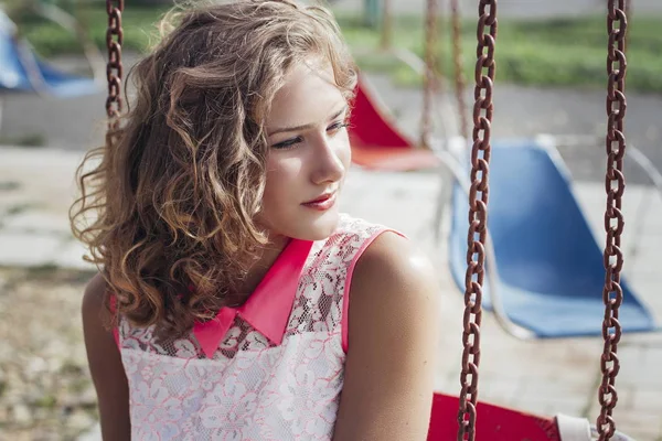 Szép fiatal szőke lány élvezi a nyár a parkban a régi túrák és körhinta — Stock Fotó