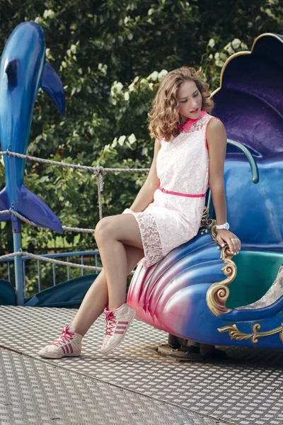 Hermosa joven rubia disfrutando del verano en el parque de paseos y carruseles viejos —  Fotos de Stock