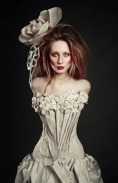 Красивая рыжая девушка в элегантном бумажном платье. Чувственный образ с ярким макияжем. Модель красоты
