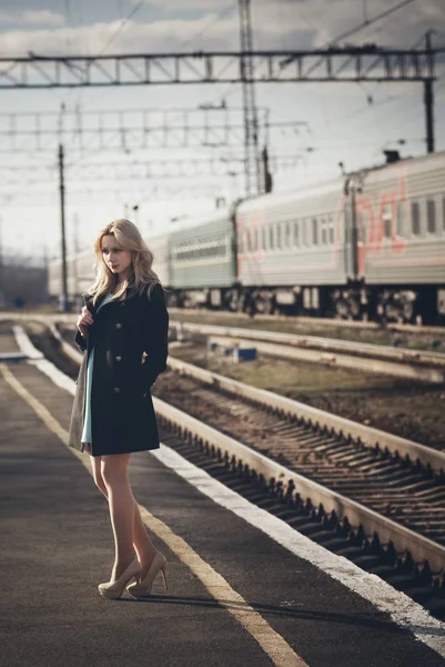 Hermosa chica rubia esperando el tren en la estación. mirada romántica, delicada — Foto de Stock