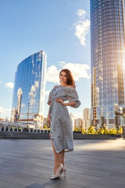 Güzel kız zarif elbise ve çekici gülümseme Yekaterinburg şehir fotoğrafçı için poz. İşten sonra iş kız yürüyor