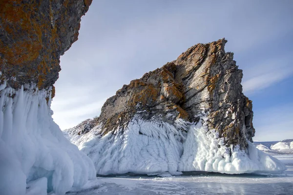 Jezioro jest pokryta grubą warstwą lodu. Historia lodu. Kamień skały wystające spod sterty lodu. Najczystsze jezioro na świecie, jezioro Bajkał — Zdjęcie stockowe